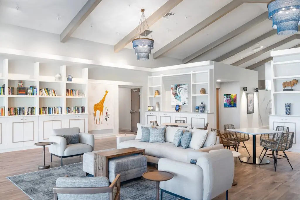 Interior image of Resilient Retreat's great room. Bookshelves line the walls, with comfortable furniture throughout.